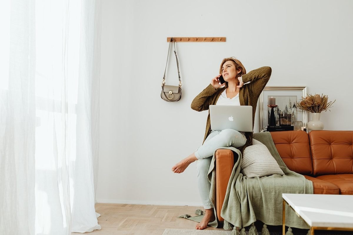Une femme travaille à distance depuis son salon détendue Une femme travaille à distance depuis son salon détendue