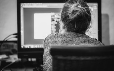 Une femme avec cheveux en chignon regarde l'écran d'ordinateur