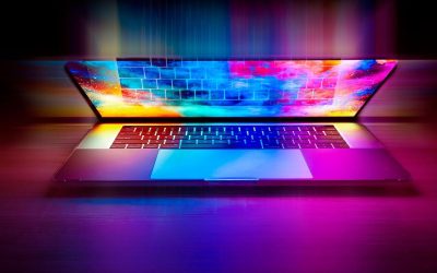 Un ordinateur portable illuminé par des néons multicolores sur fond sombre