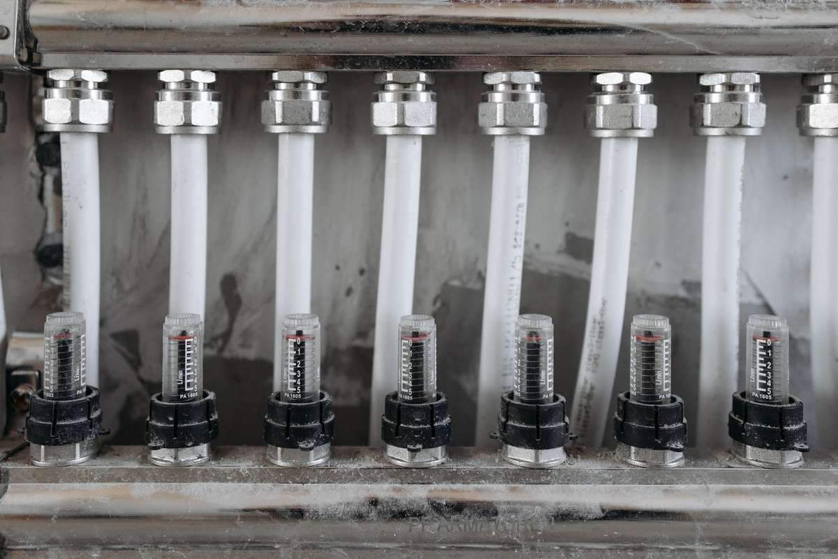 Photo montrant une rangée de tubes blancs avec raccords et connecteurs noirs
